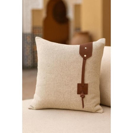 Coussin en toile beige avec une petite touche en cuir