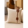 Coussin en toile beige avec une petite touche en cuir